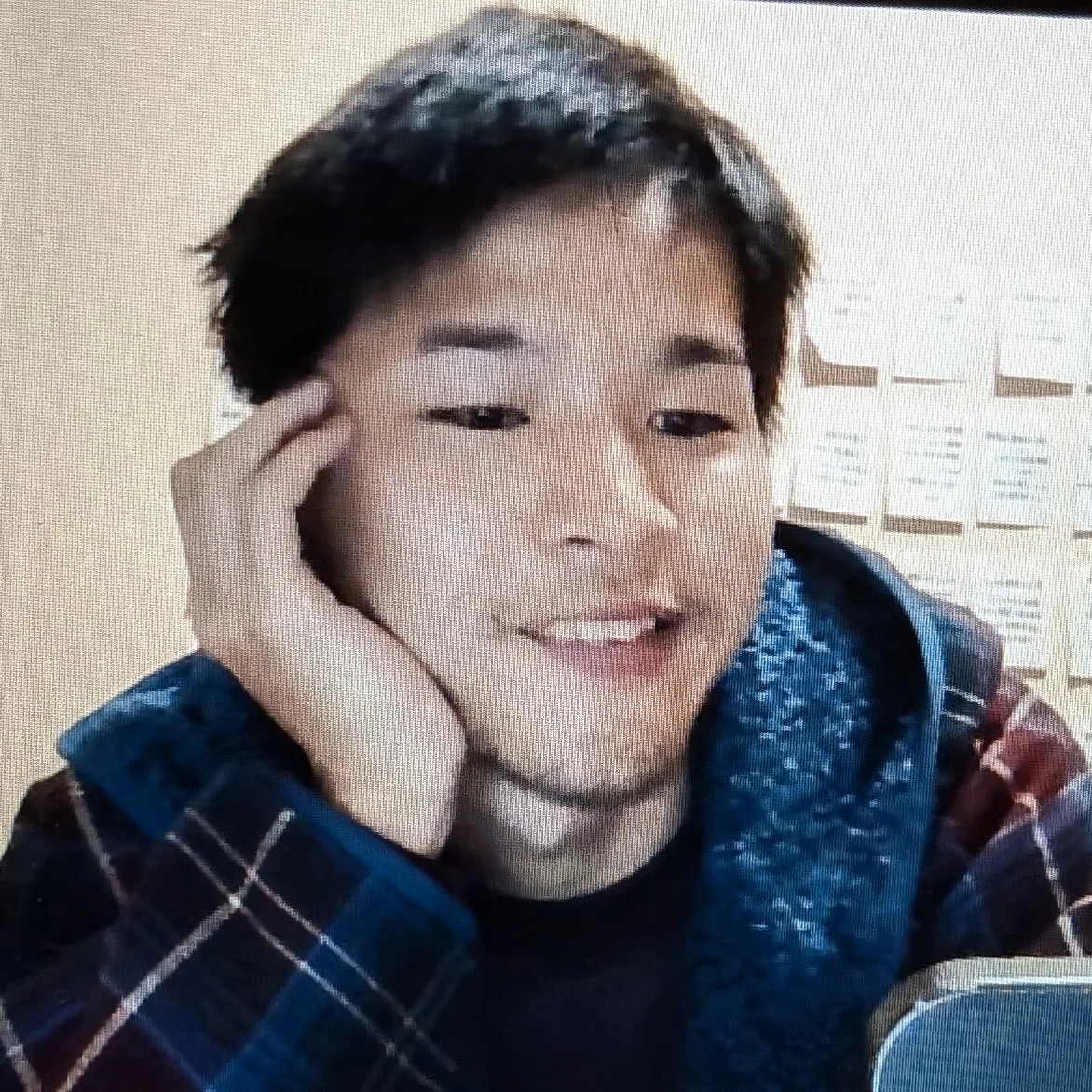 Hokuto Torigoe, smiling, chin resting on one hand